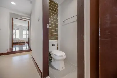 a bathroom with a white toilet and a mirror at Moondance House Chinatown in Bangkok