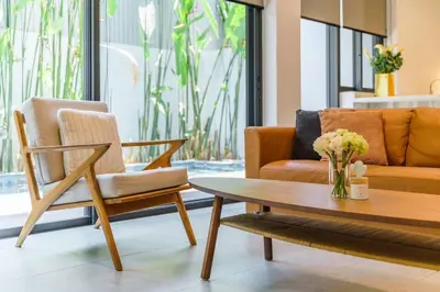 a living room with two chairs and a coffee table at Designer 49 Pool Villa in Bangkok