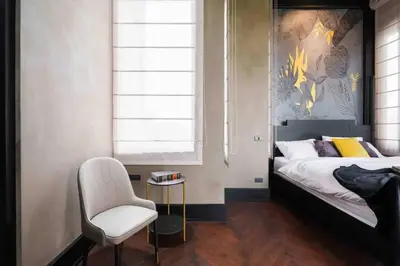 a bedroom with a bed and a white chair at Luxury Modern Pool Jacuzzi Villa 5BR Thonglor in Khlong Toei