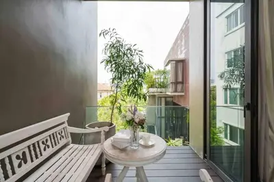 a balcony with a table and a bench and a window at Luxury Modern Pool Jacuzzi Villa 5BR Thonglor in Khlong Toei