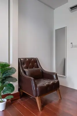 a brown leather chair sitting in a room at Sunfire House Chinatown in Bangkok