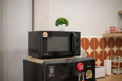 a microwave sitting on top of a refrigerator at Sunfire House Chinatown in Bangkok