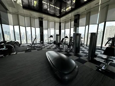a gym with a large room with large windows at City Oasis: 5 Min to Metro, Pool & Gym, Essentials in Khlong Toei