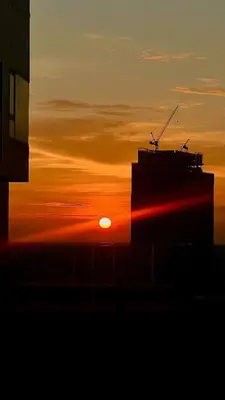 a sunset with the silhouette of a building at City Oasis: 5 Min to Metro, Pool & Gym, Essentials in Khlong Toei