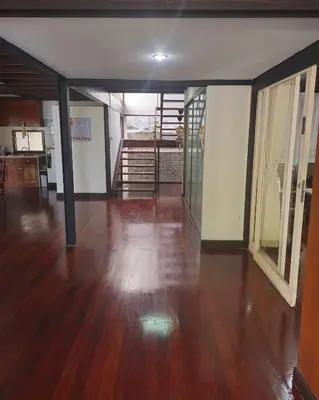 an empty living room with wood floors and a staircase at AT ASok Vintage House Near BTS Asok MRT Sukhumvit in Khlong Toei