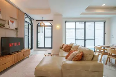 a living room with a couch and a tv at Ayas Retreat - Muji Ekkamai Pool Villa with 4 bedrooms in Khlong Toei