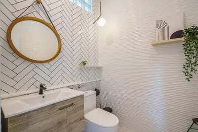 a bathroom with a sink and a mirror and a toilet at Ayas Retreat - Muji Ekkamai Pool Villa with 4 bedrooms in Khlong Toei