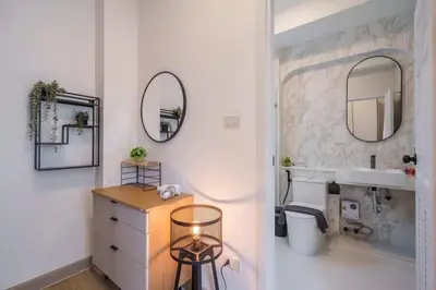 a bathroom with a sink and a toilet and mirrors at Ayas Retreat - Muji Ekkamai Pool Villa with 4 bedrooms in Khlong Toei
