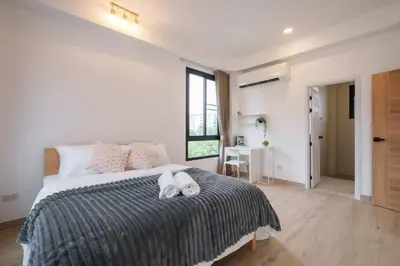 a bedroom with a bed with a white dog laying on it at Ayas Retreat - Muji Ekkamai Pool Villa with 4 bedrooms in Khlong Toei