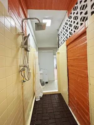 a shower stall in a bathroom with a wooden door at Top Location! 800m MRT Rama9 in Bangkok