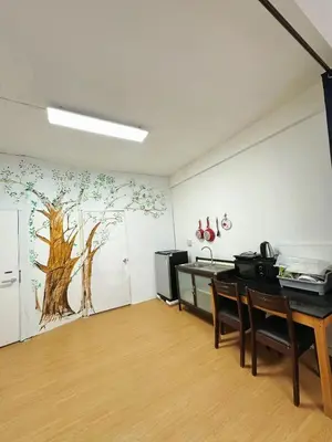 a room with a table and a tree mural on the wall at Top Location! 800m MRT Rama9 in Bangkok