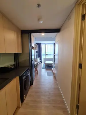 a kitchen with a hallway leading to a living room at Rama9 Loft Life in Bangkok
