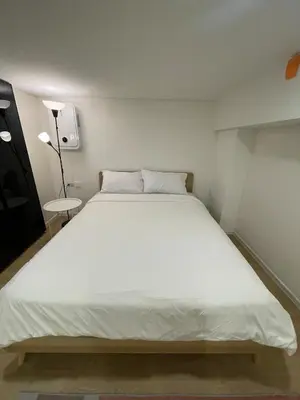 a large white bed in a small room at Rama9 Loft Life in Bangkok