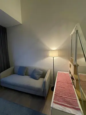 a living room with a couch and a lamp at Rama9 Loft Life in Bangkok