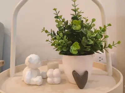a white vase with a potted plant and a candle at Secret Muji Vintage Building ห้องลับมูจิในตึกวินเทจ in Ban Song Hong