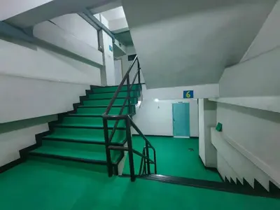 a staircase in a building with a green floor at Secret Muji Vintage Building ห้องลับมูจิในตึกวินเทจ in Ban Song Hong