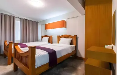 a bedroom with two beds and a window at GO INN Khaosan - โกอินน์ ตรอกข้าวสาร in Bangkok