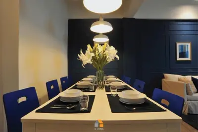 a dining room table with a vase of white flowers at Baan Sri-kram 550m from MRT Taopoon in Bang Su