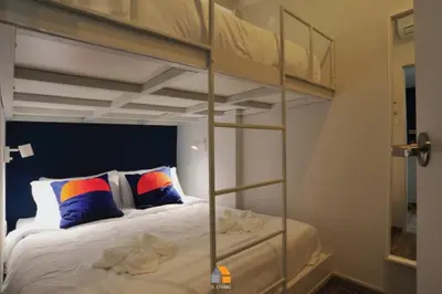 a bedroom with two bunk beds with colorful pillows at Baan Sri-kram 550m from MRT Taopoon in Bang Su