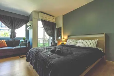 a bedroom with a large bed and a couch at TC Contel At BTS Onnut Century in Amphoe Phra Khanong