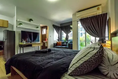 a bedroom with a large bed and a television at TC Contel At BTS Onnut Century in Amphoe Phra Khanong