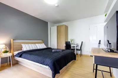 a bedroom with a bed and a desk and a table at TC Contel At BTS Onnut Century in Amphoe Phra Khanong