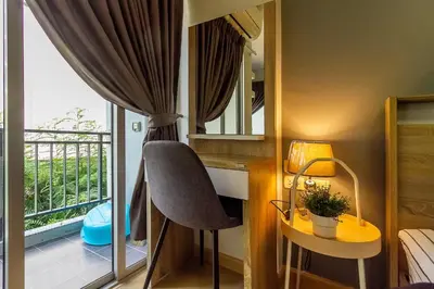 a bedroom with a desk and a chair and a window at TC Contel At BTS Onnut Century in Amphoe Phra Khanong