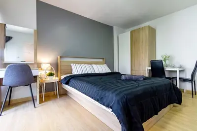 a bedroom with a bed and a table and chairs at TC Contel At BTS Onnut Century in Amphoe Phra Khanong
