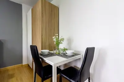 a dining room table with two chairs and a white table at TC Contel At BTS Onnut Century in Amphoe Phra Khanong