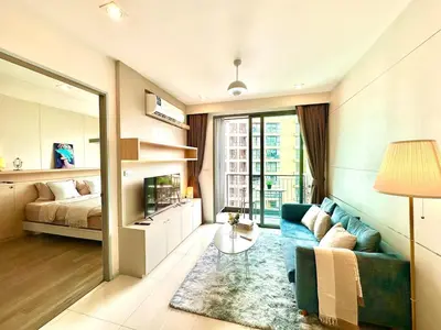 a living room with a couch and a bed at Bright & Spacious Apartment in Bangkok