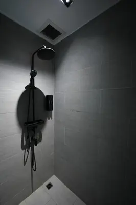 a bathroom with a shower with a light on the wall at baansaensaep in Pratunam