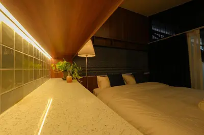 a bedroom with a bed and a table with a plant at baansaensaep in Pratunam