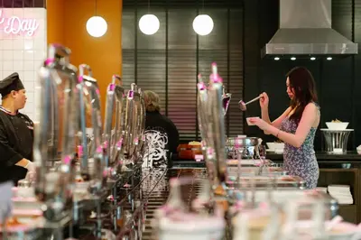 a woman standing in front of a row of wine glasses at Vince Hotel Pratunam in Bangkok