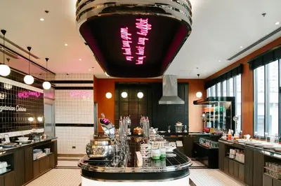 a restaurant with a large light hanging from the ceiling at Vince Hotel Pratunam in Bangkok