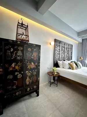 a bedroom with a large bed and a dresser at Stylish Studio in Prime Sukhumvit-Next to BTS Nana in Bangkok