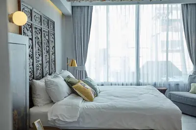 a bedroom with a large bed with a large window at Stylish Studio in Prime Sukhumvit-Next to BTS Nana in Bangkok