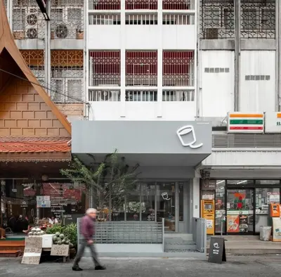 a man walking down a street in front of a building at Stylish Studio in Prime Sukhumvit-Next to BTS Nana in Bangkok