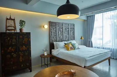 a bedroom with a large bed and a table at Stylish Studio in Prime Sukhumvit-Next to BTS Nana in Bangkok