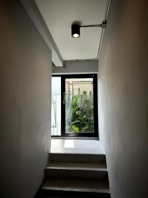 a stairway leading to a window in a building at Spacious duplex 2 BR apartment max 6 guests - 3 min walk to BTS Nana in Bangkok