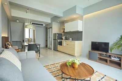 a living room with a couch and a table at Spacious duplex 2 BR apartment max 6 guests - 3 min walk to BTS Nana in Bangkok