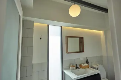 a white bathroom with a sink and a mirror at Spacious duplex 2 BR apartment max 6 guests - 3 min walk to BTS Nana in Bangkok