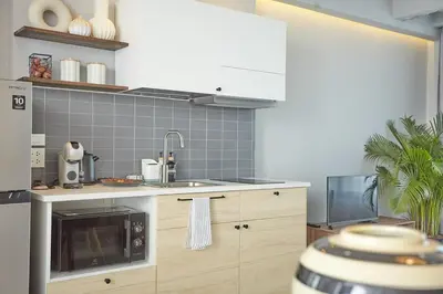 a kitchen with a sink and a microwave at Spacious duplex 2 BR apartment max 6 guests - 3 min walk to BTS Nana in Bangkok