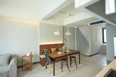 a living room with a wooden table and chairs at Spacious duplex 2 BR apartment max 6 guests - 3 min walk to BTS Nana in Bangkok