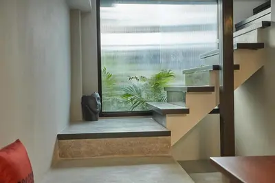 a staircase in a room with a large window at Stylish duplex 2 BR apartment - 3 mins walk to BTS Nana in Bangkok
