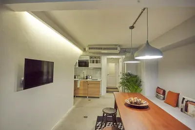 a living room with a dining table and a kitchen at Stylish duplex 2 BR apartment - 3 mins walk to BTS Nana in Bangkok