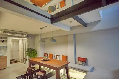 a dining room with a wooden table and chairs at Stylish duplex 2 BR apartment - 3 mins walk to BTS Nana in Bangkok