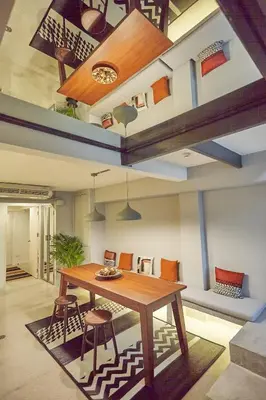 a living room with a wooden table and chairs at Stylish duplex 2 BR apartment - 3 mins walk to BTS Nana in Bangkok