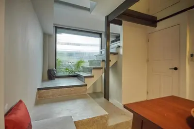 a room with stairs and a window and a door at Stylish duplex 2 BR apartment - 3 mins walk to BTS Nana in Bangkok