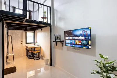 a living room with a flat screen tv on a wall at 94Home Donmuang in Bang Khen
