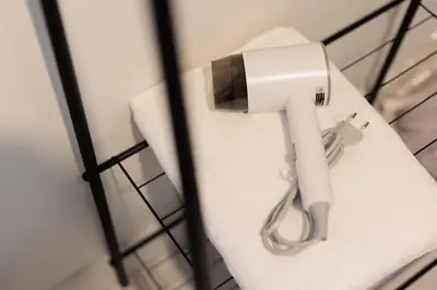 a white hair dryer sitting on top of a toilet at 94Home Donmuang in Bang Khen